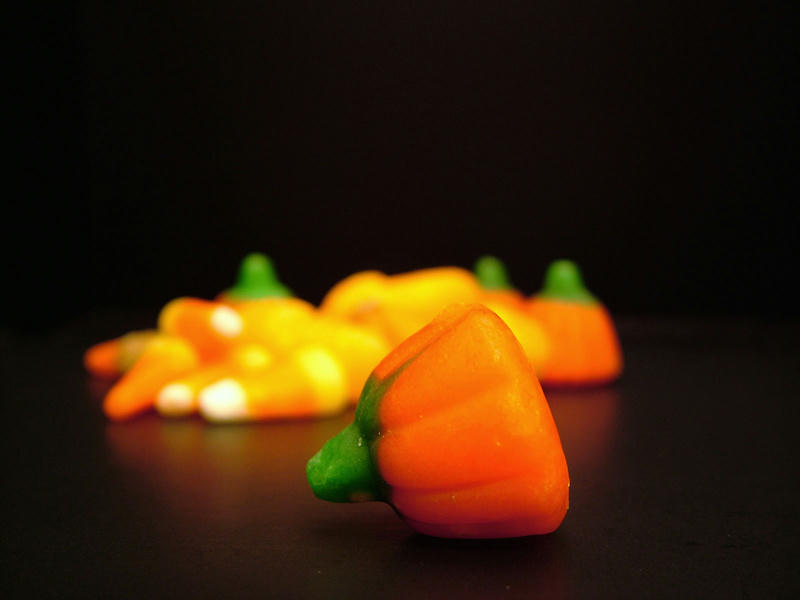 A picture of a candy pumpkin with similar candy in the background